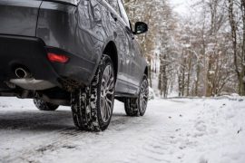 Voiture qui roule sur la neige avec des pneus hiver
