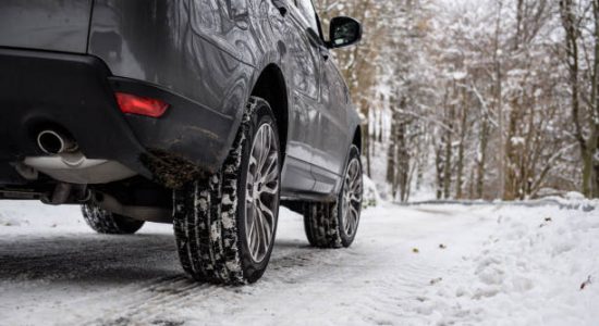 Voiture qui roule sur la neige avec des pneus hiver